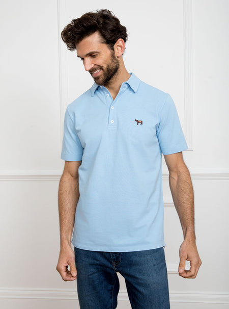 Man wearing sky blue polo shirt in 100% cotton with Newmarket 875 horse logo embroidered on the front.